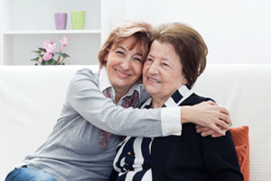 Caregiver smiling hugging women