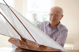 Elderly Man holding Boat Model